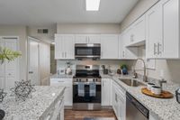 Kitchen with granite counters, stainless appliances, and modern cabinetry