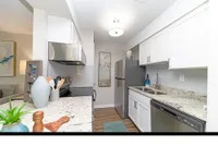 Bright, modern kitchen featuring sleek white cabinetry, stainless steel appliances, and elegant granite countertops.