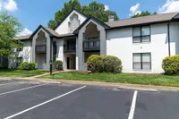 Charming modern apartment building with elegant balconies and a lush green exterior, promising a serene living environment.