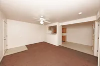 Spacious living room with carpet & ceiling fan