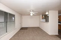 Spacious living room with carpet & ceiling fan