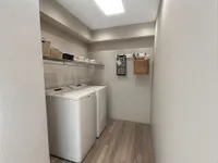 Laundry room with built in storage and hardwood style flooring