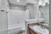 Bright bathroom with tile backsplash and bathtub