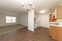 Dining + Kitchen area with hardwood-style flooring