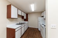 Kitchen with white appliances, wooden cabinetry, and ample counterspace
