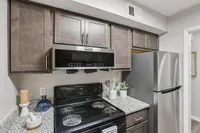 Kitchen with granite counters, black appliances, and modern cabinetry
