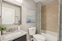 Bright bathroom with granite counters and bathtub