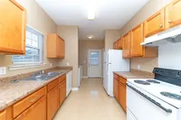 Kitchen with white appliances, wooden cabinetry, and generous counterspace