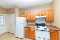 Kitchen with white appliances, wooden cabinetry, and generous counterspace