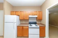 Kitchen with white appliances, wooden cabinetry, and generous counterspace