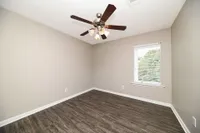 Bedroom with hardwood-style flooring and ceiling fan