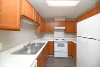 Kitchen with white appliances, wooden cabinetry, and ample counterspace