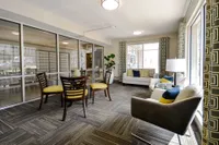 Inviting urban lounge area with contemporary furniture, bright accents, and floor-to-ceiling windows offering ample natural light.