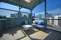 Chic rooftop patio with stylish seating, offering a stunning city skyline view and perfect for entertaining.
