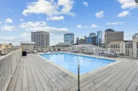 Rooftop oasis featuring a sparkling swimming pool with stunning cityscape views and surrounding lounge chairs for relaxation.