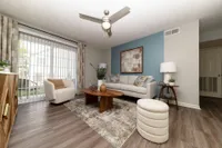 Spacious living room with hardwood-style flooring & ceiling fan