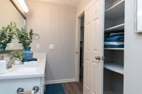 Bathroom with quartz counters & linen closet with built-in shelving