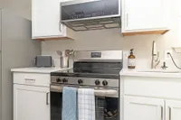 Kitchen with quartz counters, modern cabinetry, & stainless appliances