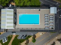 Chic rooftop swimming pool with a spacious deck, surrounded by stylish lounge chairs, offering a luxurious urban escape.