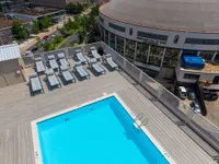 Inviting rooftop pool with chic sun loungers offering stunning cityscape views next to the Musicians Hall of Fame.