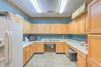 Charming U-shaped kitchen featuring ample wooden cabinetry, sleek countertops, and modern appliances for a cozy cooking experience.