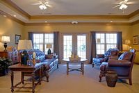 Elegant living room with luxurious leather sofas, ambient lighting, and large windows offering abundant natural light.