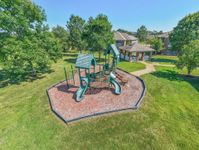 Vibrant apartment community playground nestled in lush green surroundings, perfect for family fun and outdoor relaxation.