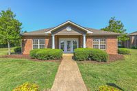 Charming brick apartment with elegant entrance, well-maintained garden, and picturesque surroundings.