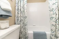 Bright bathroom with quartz counters & bathtub