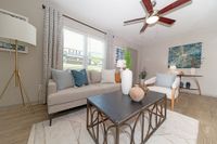 Spacious living room with hardwood-style flooring & ceiling fan