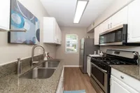 Kitchen with granite counters, modern cabinetry, and stainless appliances