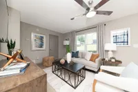 Spacious living room with hardwood-style flooring & ceiling fan