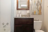 Bright bathroom with granite counters and bathtub