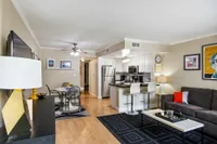 Contemporary open-plan living area showcasing a cozy lounge, elegant dining space, and modern kitchen with sleek appliances.