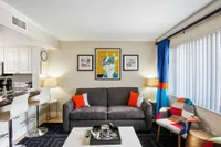 Cozy and colorful living room featuring a comfy sofa with bright cushions, modern art, and vibrant accents perfect for relaxation and style.
