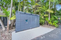 Convenient Amazon Hub locker set amid lush tropical greenery, offering easy package access for residents.