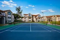 Full-sized, lakeside tennis court with evening lighting