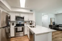 Quartz countertops with breakfast bar, dishwasher, & disposal