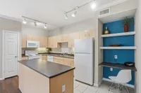 Kitchen equipped with an island, pantry and a built in shelving and computer space
