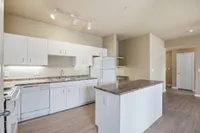 Classic Kitchen with granite countertops with white appliances with great storage.