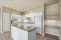 Large Kitchen with amble storage space, built in island, pantry, and built-in desk with shelving.