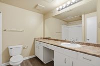 Large Bathroom with ample countertop space, vanity nook for stool and under cabinet storage.