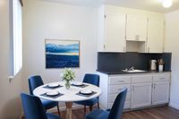 Dining area next to kitchen counter with white cabinetry