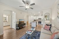Bright and inviting open-concept living room with modern kitchen, featuring stylish furniture and elegant decor.