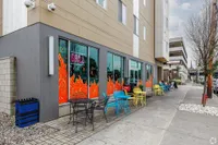 Vibrant urban cafe with colorful outdoor seating and eye-catching flame-themed window art.