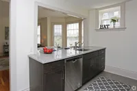 Bright, modern kitchen with a granite countertop, stainless steel appliances, and a cozy view of the living area.