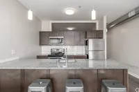 Modern kitchen with sleek granite countertops, stainless steel appliances, and elegant lighting, perfect for entertaining.