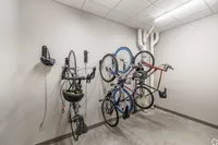 Modern bike storage room with neatly mounted bicycles and bright overhead lighting.