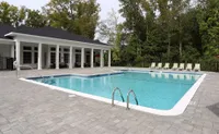 Inviting outdoor pool area surrounded by elegant sun loungers and lush greenery, perfect for relaxation and leisure.