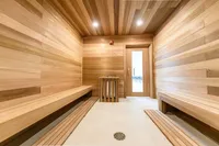 Inviting wooden sauna room with sleek benches and soft overhead lighting, perfect for relaxation and rejuvenation.